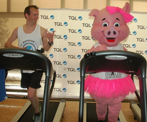 TQL Employee Running On A Treadmill Alongside The Flying Pig Mascott