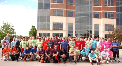 Large Group Of Employees Smiling With Basketballs In Front Of The TQL Building