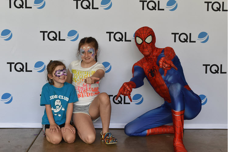 Kids pose with Spider Man at TQL's superhero-themed summer picnic