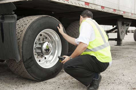 Man inspecting truck tire