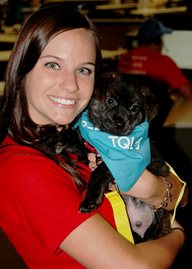 Woman holding puppy with blue TQL bandanna