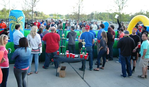 Large gathering outside with inflatable obstacle course