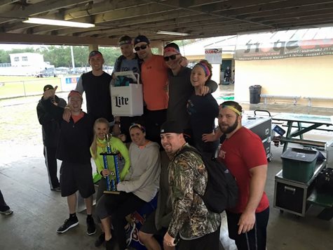 Group Of Employees Smiling With A Trophy And A Cooler Of Beer