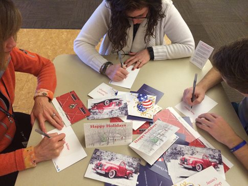 People writing cards around a table