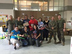 People and army men holding gifts posing for a picture