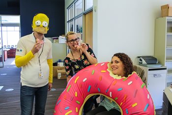 Person in homer costume, and a person holding an inflatable doughnut