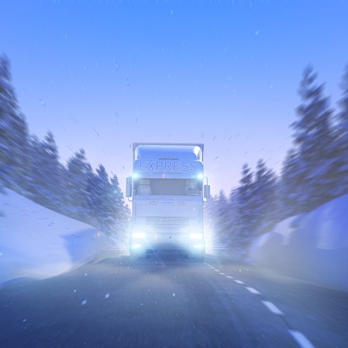 Semi truck driving through snow covered landscape