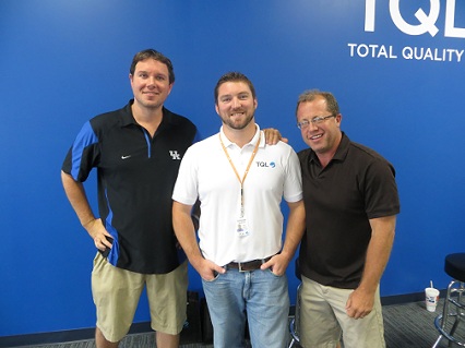 Three men posing behind blue screen