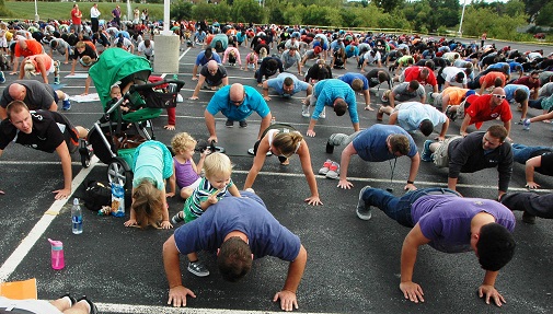 Group of men in parking lot doing pushups