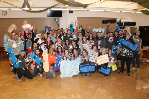 A Large Group Of People Smile While Holding Toys For Children