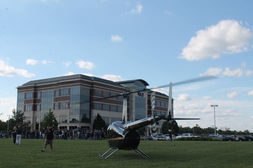 A Helicopter Landind On The Grass Outside The TQL Building