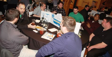 A Group Of Men With Drinks Playing Trivia