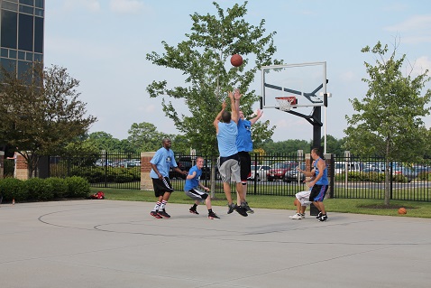 Men playing a basketball game on outside courts