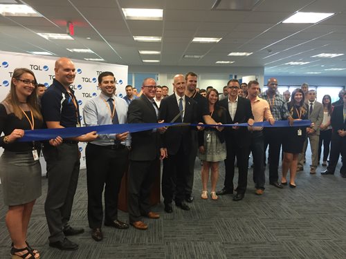 Business people holding a long blue ribbon and scissors