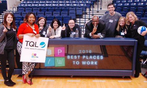 Employees Holding Up A #1 With Their Fingers Smiling With A Sign That Says 2016 Best Places To Work