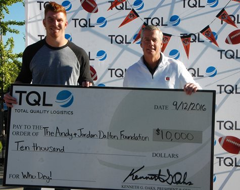 Andy Dalton And Kerry Byrne Smiling And Holding A Giant Check